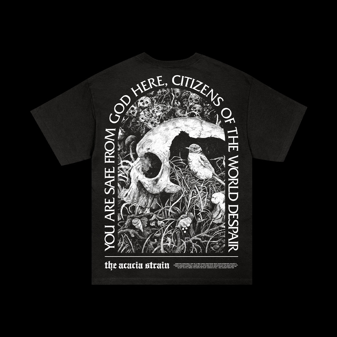 Black Comfort Colors T-shirt by The Acacia Strain with a large skull, plants, smaller skulls, and curved white text: “You are safe from God here, citizens of the world despair.” Presale; ships 8/15/25.