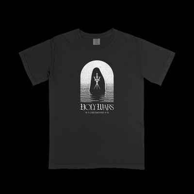 Holy Wars black Comfort Colors t-shirt featuring a white hooded figure with a chest symbol standing in water under an arch, “HOLY WARS” in bold below, and smaller accent text—a striking graphic tee from Holy Wars.