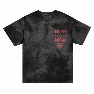 A black crystal dye T-shirt from Dance Gavin Dance features "DANCE GAVIN DANCE" in pink and orange, stacked three times on the left chest above small orange text. This presale item is ideal for fans of unique printed apparel.