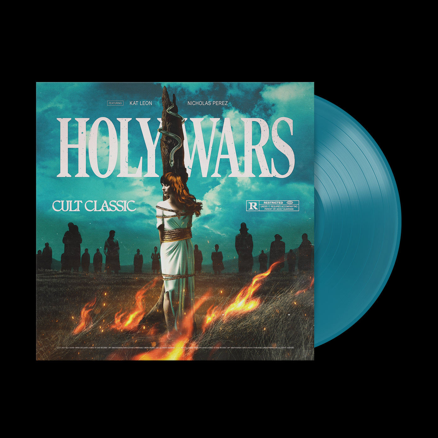 A limited edition aqua vinyl by Holy Wars beside its cover, featuring a woman tied to a burning stake with a cross behind her and silhouetted figures in the background. The cover reads "Holy Wars Cult Classic.