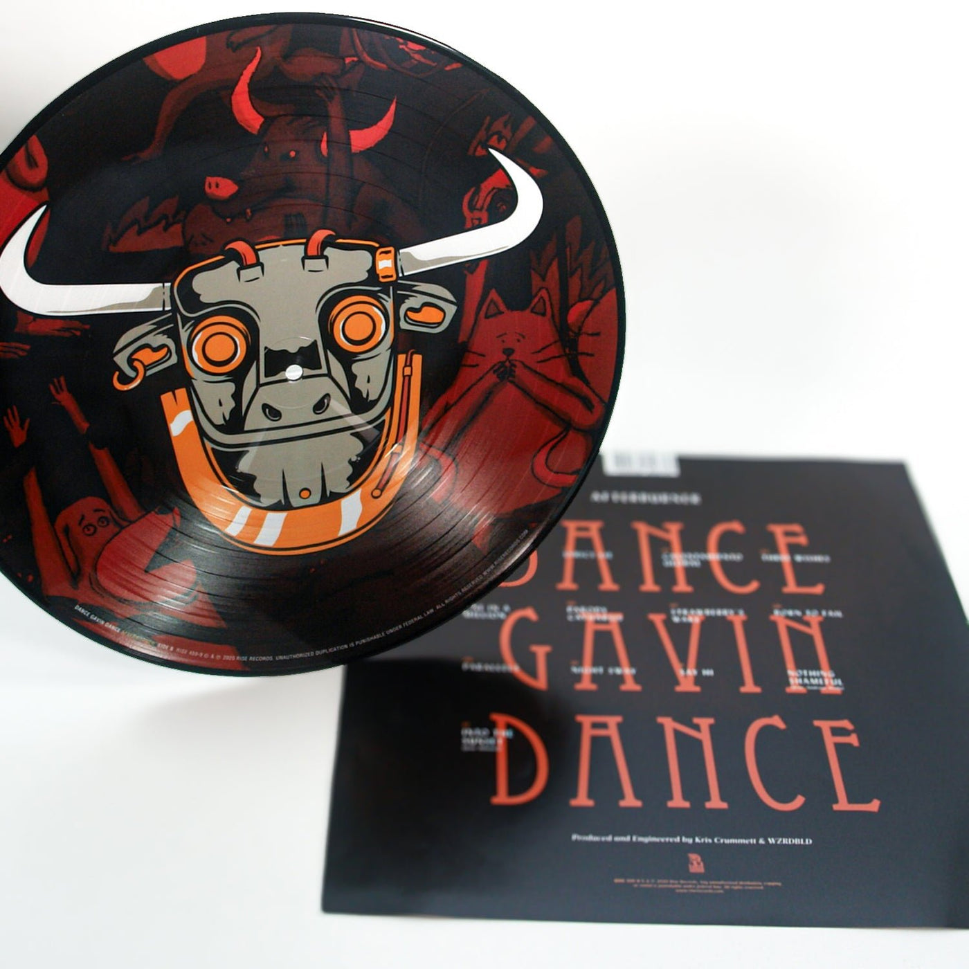 A Limited Edition Afterburner Picture Disc Vinyl LP by Dance Gavin Dance features an illustrated bull’s head in orange and gray, positioned next to its cover with bold orange “Dance Gavin Dance” text on a black background—a standout collectible.