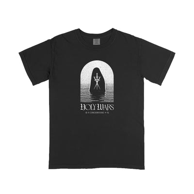 Holy Wars black t-shirt on Comfort Colors features a white graphic of a hooded figure under an arch over water. "HOLY WARS" is printed below with decorative symbols and writing for a unique printed apparel style.