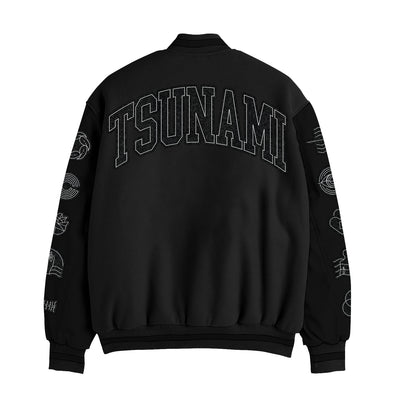 Spiritbox black wool and leather varsity jacket shown from the back features bold chenille "TSUNAMI" text across the shoulders and white wave-inspired designs on both sleeves.